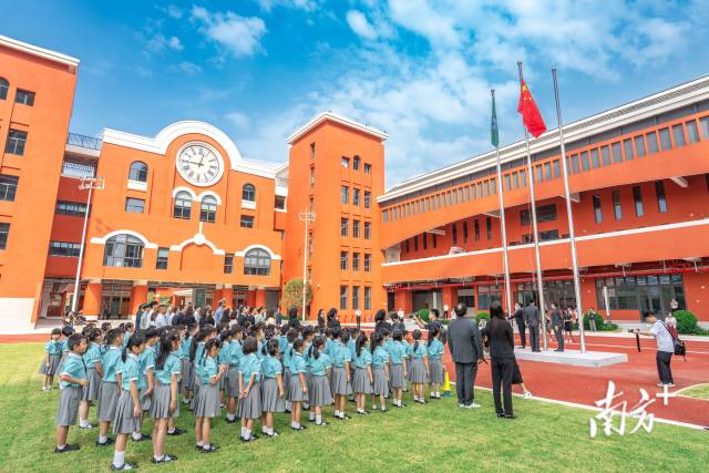 澳门新生身穿校服，背着书包来到濠江中学附属横琴学校报到。